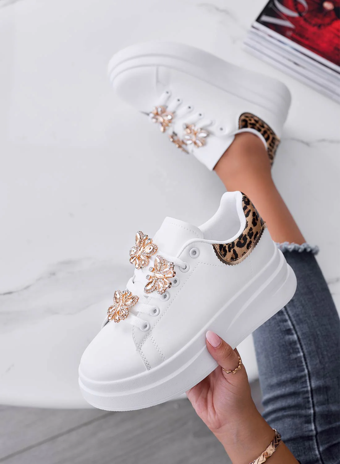 Sneakers bianche con retro maculato e farfalle gioiello oro
